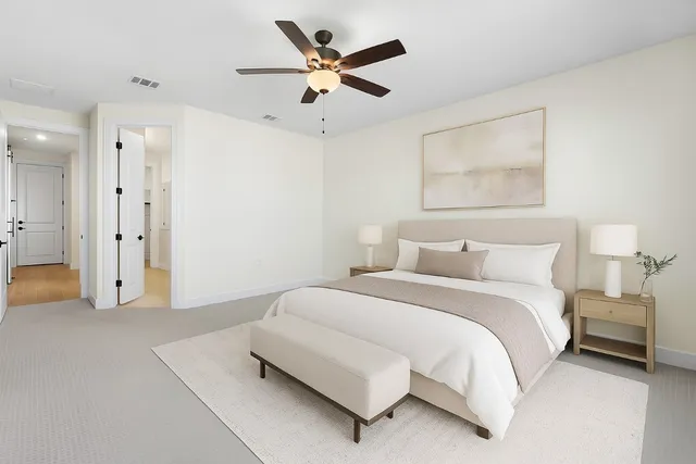 a spacious bedroom with a bed and a ceiling fan
