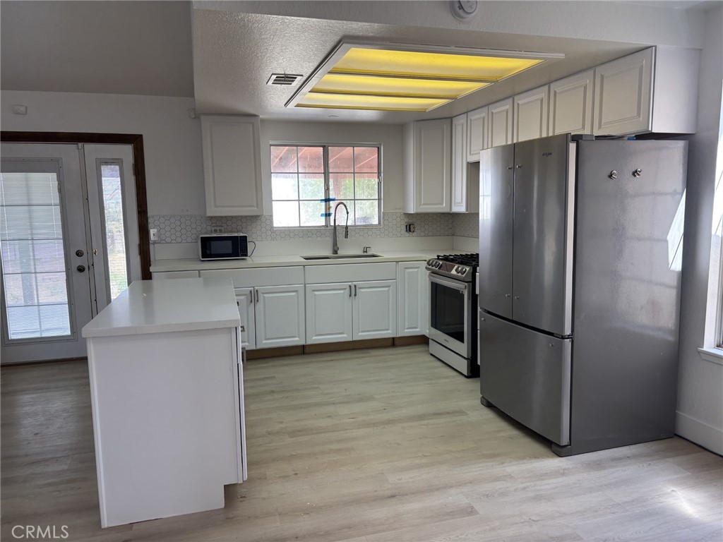 9591 Colfax Road Phelan, CA 92371 - Photo 12 of 24 a kitchen with stainless steel appliances a refrigerator and a stove top oven