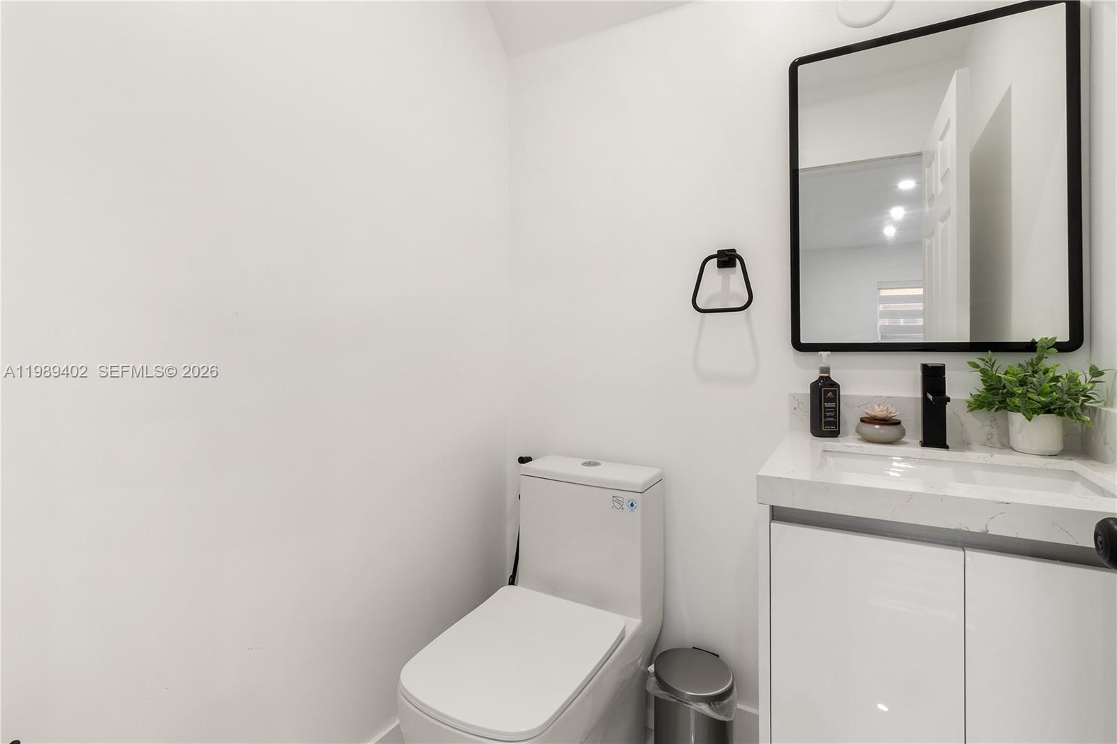 14052 Southwest 167th Terrace Miami, FL 33177 - Photo 6 of 33 a bathroom with a toilet a sink and mirror