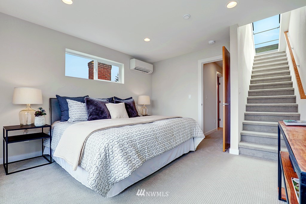 515 Northwest 70th Street Seattle, WA 98117 - Photo 23 of 32 a spacious bedroom with a bed and a cabinets