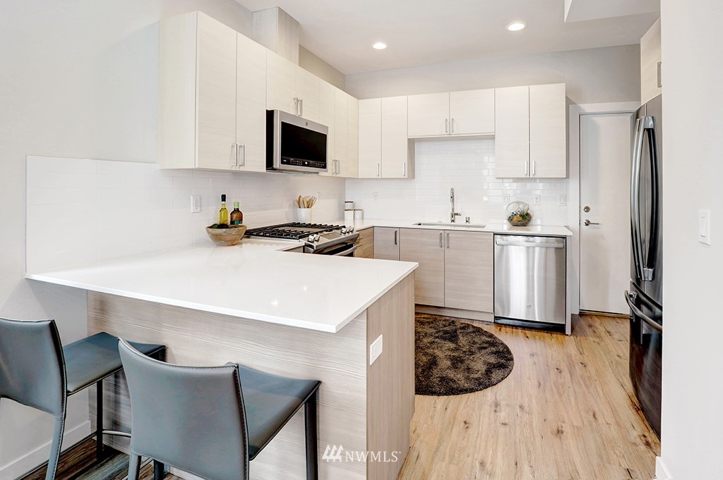 515 Northwest 70th Street Seattle, WA 98117 - Photo 9 of 32 a kitchen with a sink a stove a refrigerator and cabinets