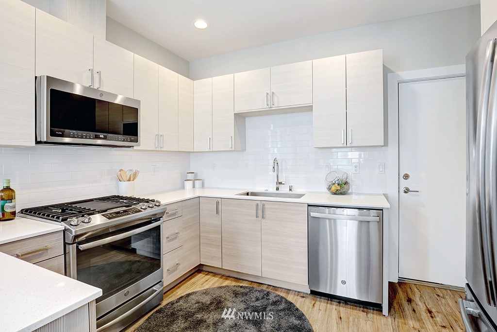 515 Northwest 70th Street Seattle, WA 98117 - Photo 10 of 32 a kitchen with stainless steel appliances granite countertop a stove a sink and a microwave