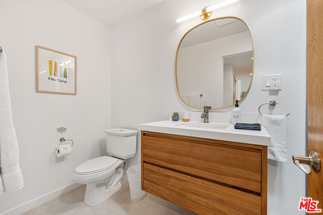 1414 Sagebrush Road Palm Springs, CA 92264 - Photo 39 of 48 a bathroom with a toilet sink and mirror