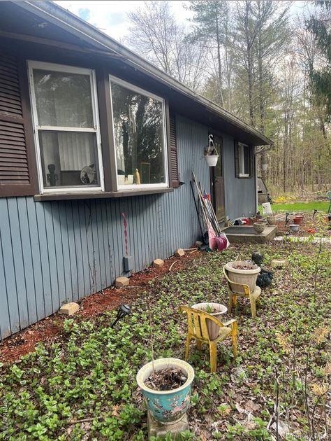 a view of a backyard with table and chairs potted plants and wooden fence