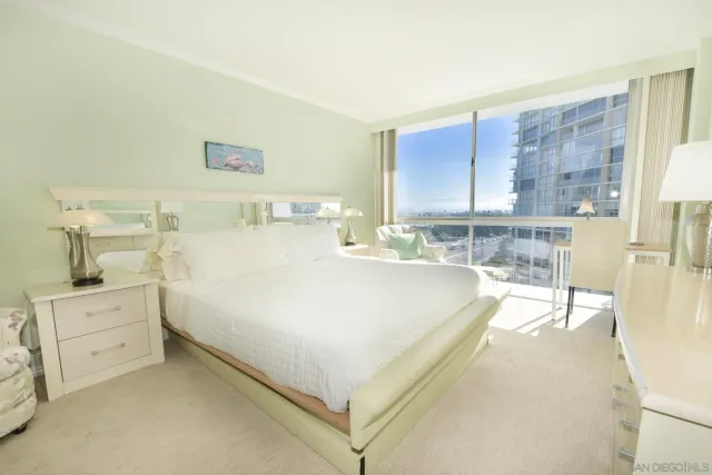 a spacious bedroom with a bed and a flat screen tv