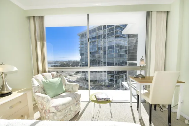 a bedroom with furniture and a large window