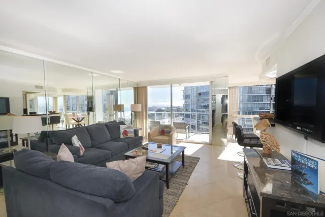 a living room with furniture a flat screen tv and a large window