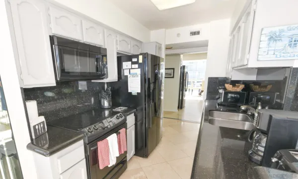 a kitchen with stainless steel appliances granite countertop a refrigerator a stove and a sink