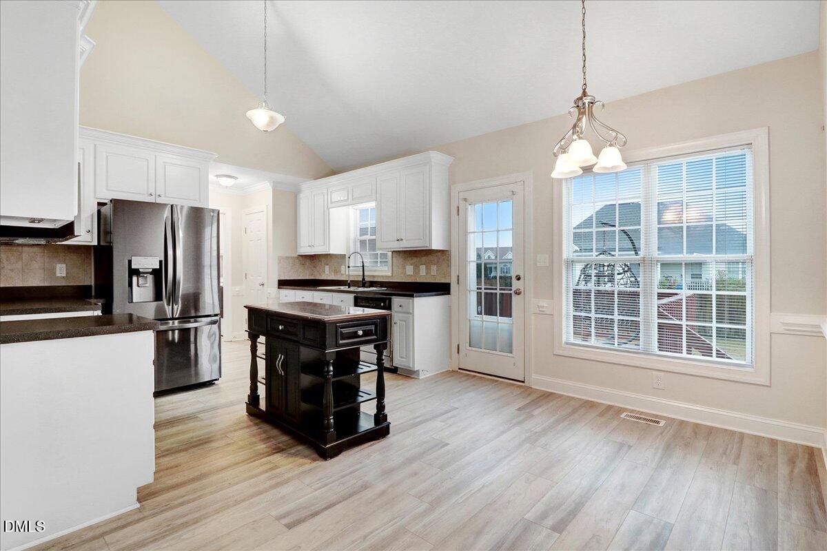 4416 Sunflower Court Wilson, NC 27896 - Photo 19 of 39 a kitchen with granite countertop a refrigerator a stove a sink cabinets and wooden floor