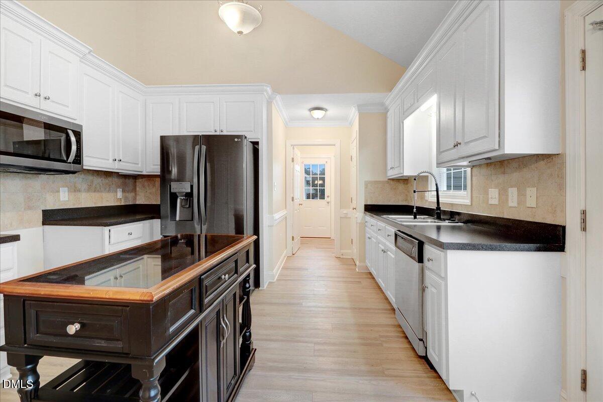 4416 Sunflower Court Wilson, NC 27896 - Photo 22 of 39 a kitchen with stainless steel appliances a refrigerator a stove a sink and white cabinets