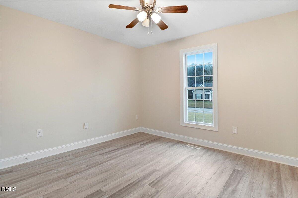 4416 Sunflower Court Wilson, NC 27896 - Photo 36 of 39 an empty room with wooden floor chandelier fan and windows