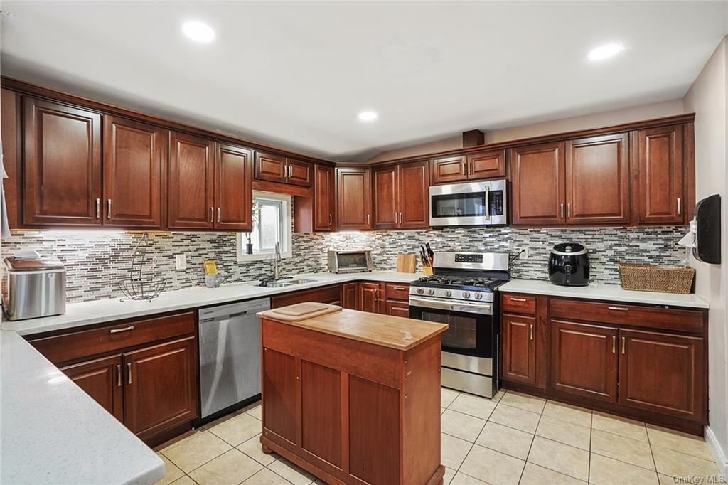 a kitchen with stainless steel appliances granite countertop wooden cabinets sink stove and granite counter top