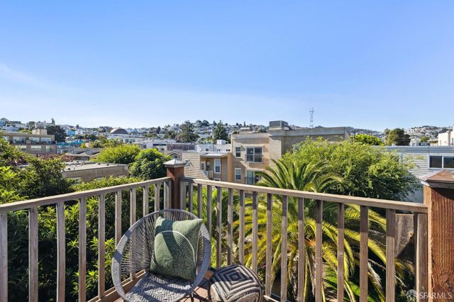 a view of a balcony with wooden floor and fence