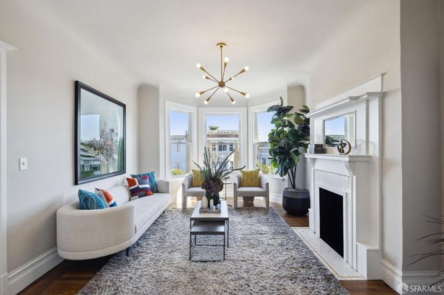 a living room with furniture a fireplace and a chandelier