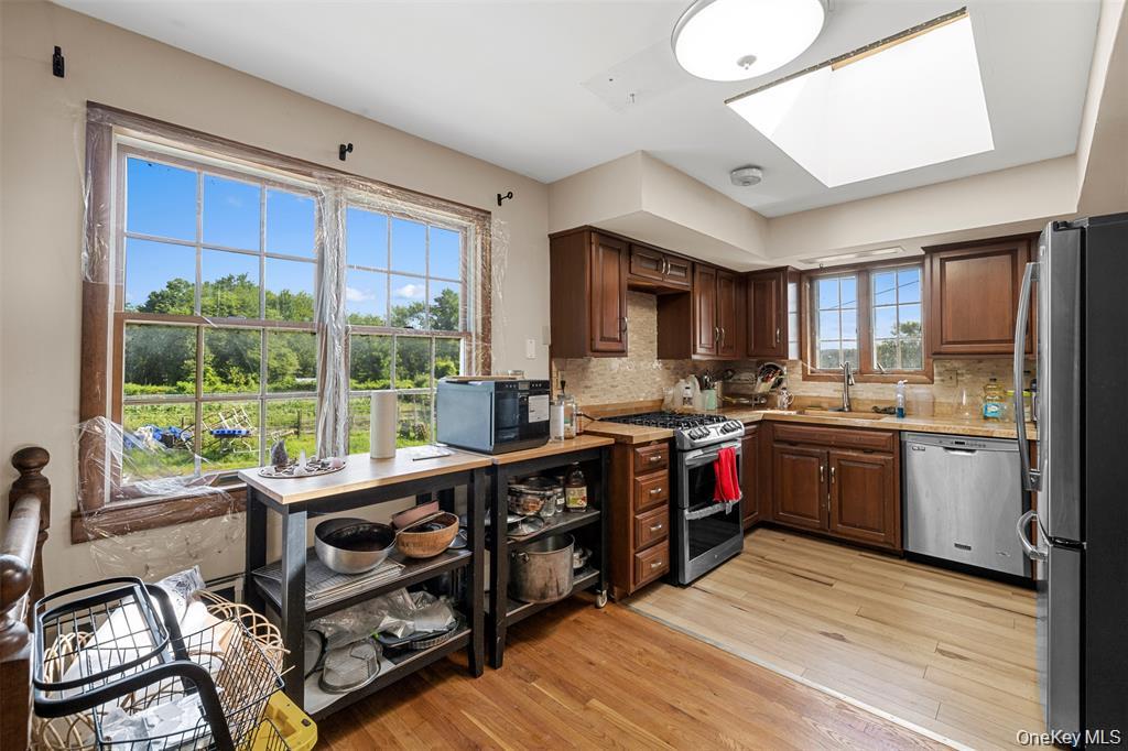 332 Springtown Road New Paltz, NY 12561 - Photo 13 of 19 a kitchen with stainless steel appliances granite countertop a stove top oven a sink dishwasher a dining table and chairs with wooden floor