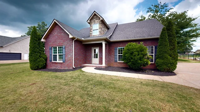 an empty room with wooden floor ceiling fan and windows
