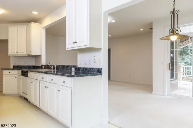 a kitchen with granite countertop white cabinets and white appliances