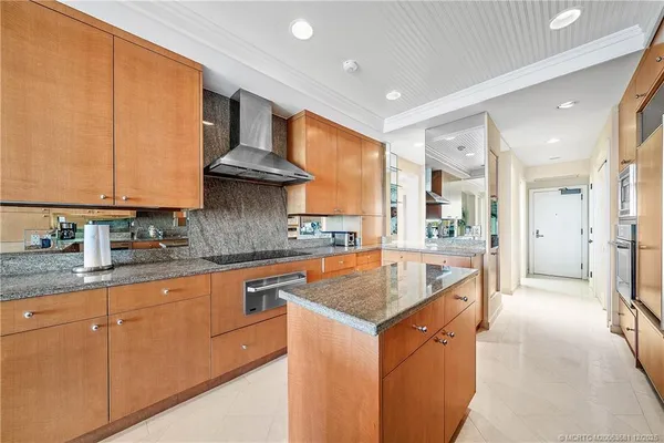 a kitchen with stainless steel appliances granite countertop a sink a stove and a refrigerator