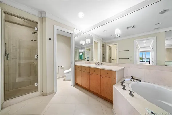 a large spacious bathroom with a tub sink mirror and shower