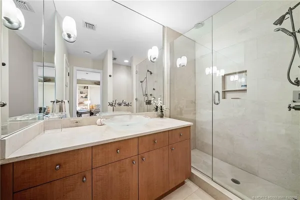 a bathroom with a double vanity sink mirror and shower