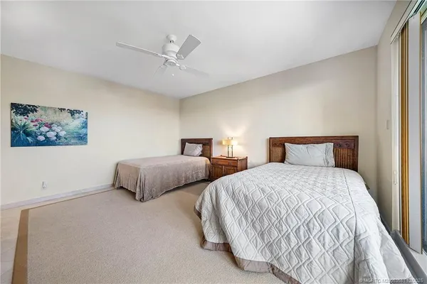 a bedroom with two beds and painting on the wall