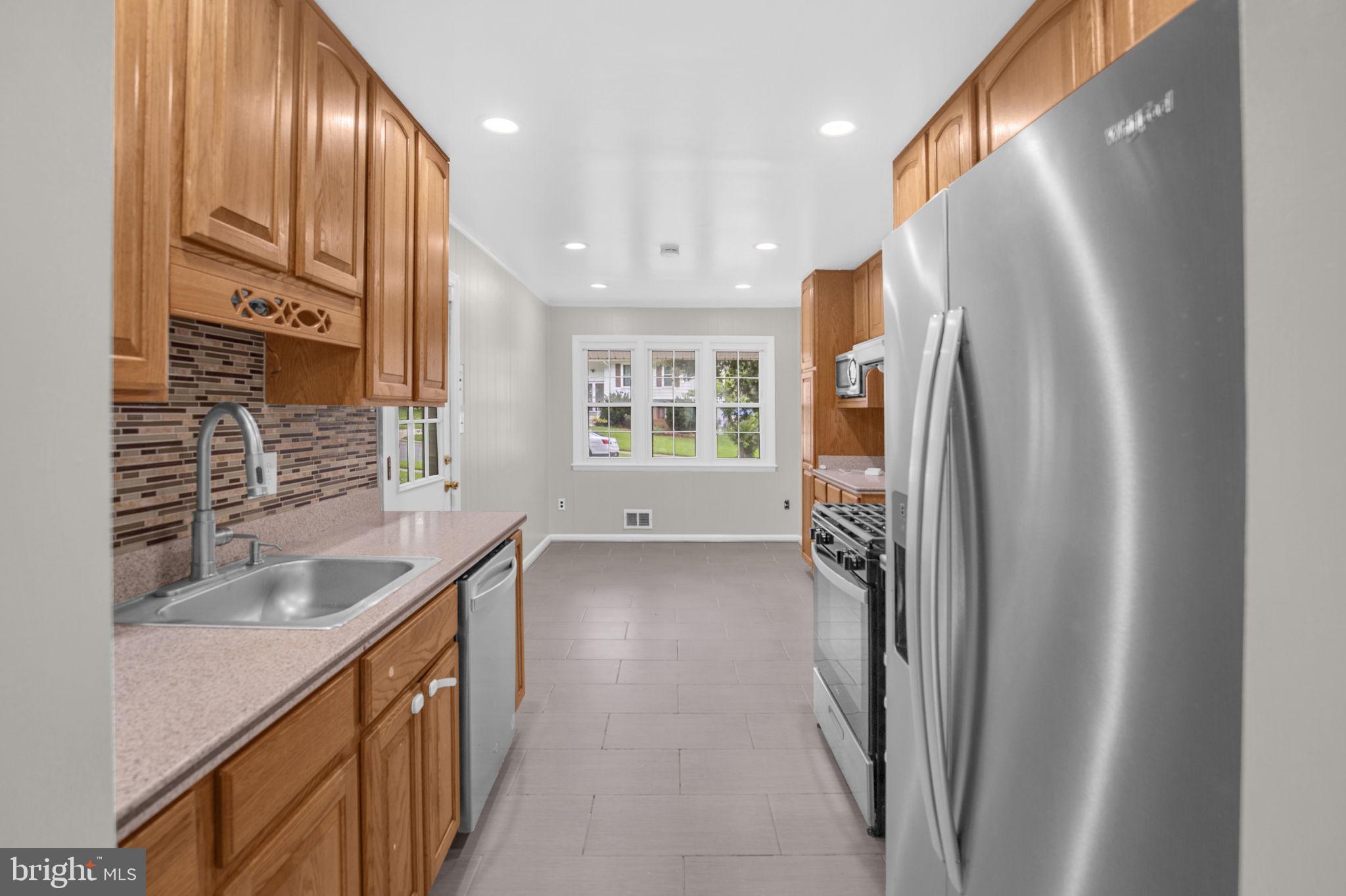 4403 Kinmount Road Lanham, MD 20706 - Photo 8 of 39 a kitchen with stainless steel appliances granite countertop a refrigerator and a sink