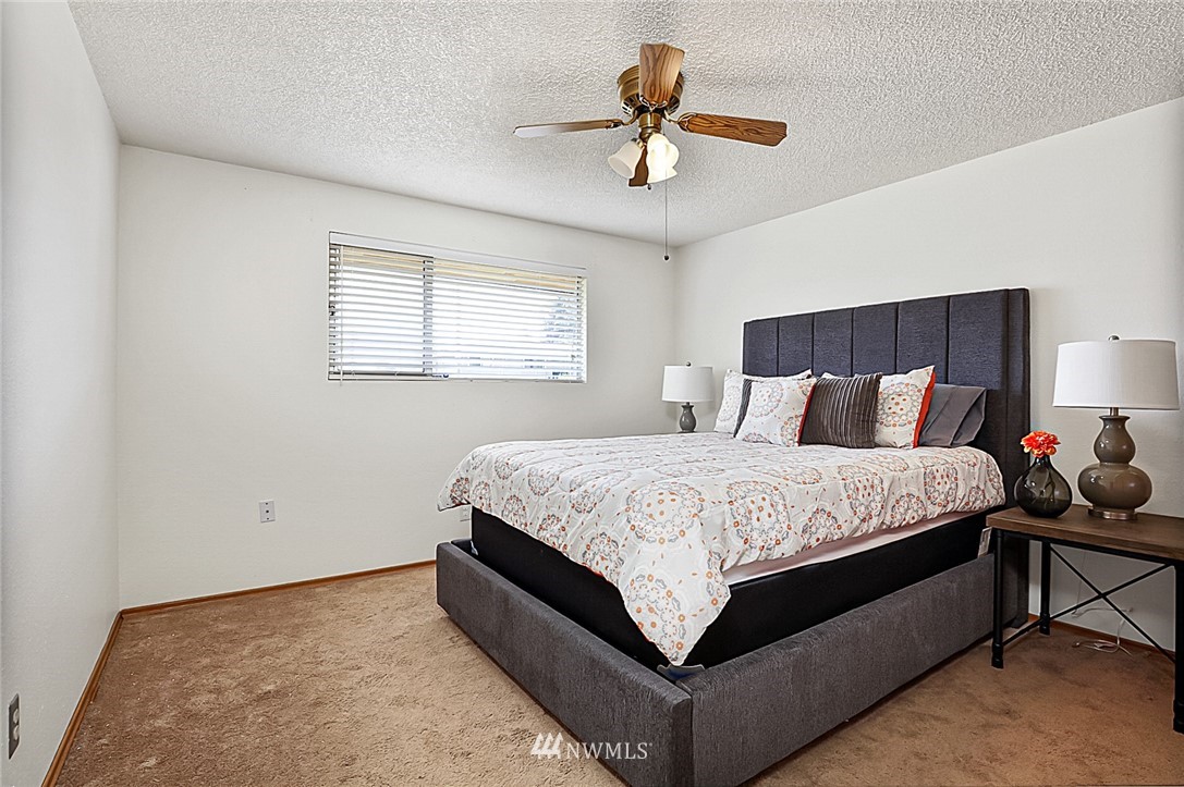 2608 Northeast 18th Street Renton, WA 98056 - Photo 14 of 20 a spacious bedroom with a bed and a chandelier