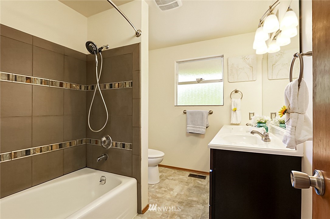 2608 Northeast 18th Street Renton, WA 98056 - Photo 15 of 20 a bathroom with a sink mirror vanity and bathtub