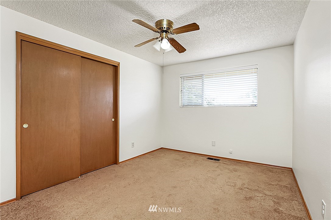 2608 Northeast 18th Street Renton, WA 98056 - Photo 19 of 20 an empty room with a ceiling fan and a window