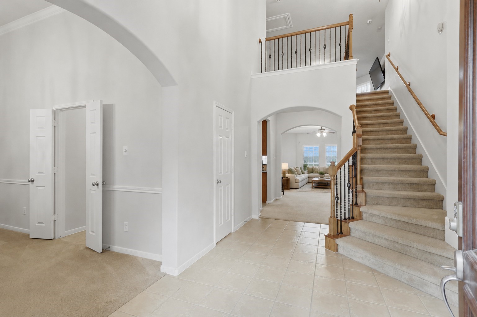 13806 Cove Landing Lane Rosharon, TX 77583 - Photo 7 of 44 The soaring entryway features an open staircase, tile flooring, and graceful archways connecting the home’s main living spaces.
