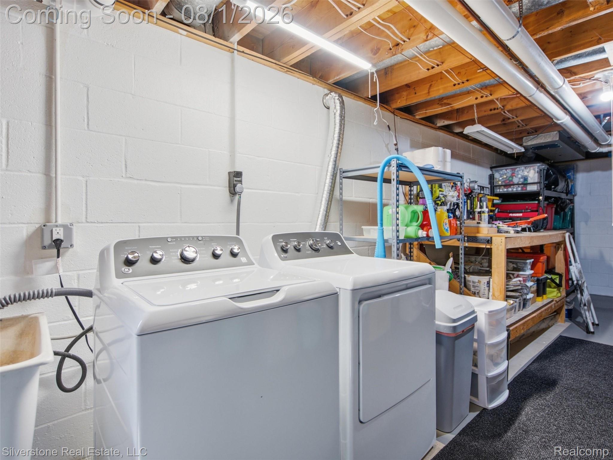 2135 Wayward Drive Rochester, MI 48309 - Photo 38 of 55 Laundry area featuring painted cinder block walls, exposed wood beam ceiling, fluorescent lighting, and a utility sink