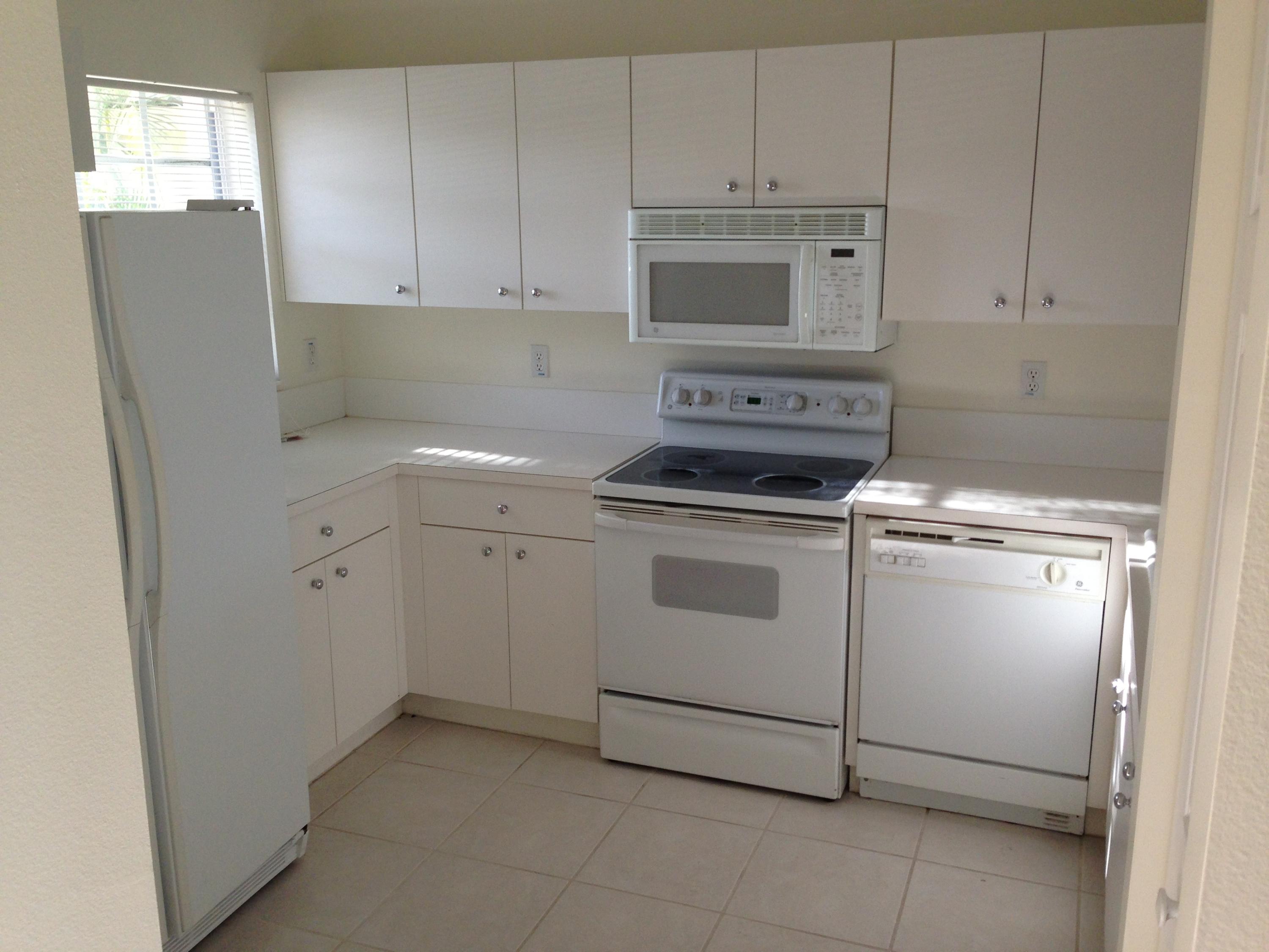 18152 Boca Way Drive Boca Raton, FL 33498 - Photo 2 of 6 a kitchen with white cabinets and white appliances
