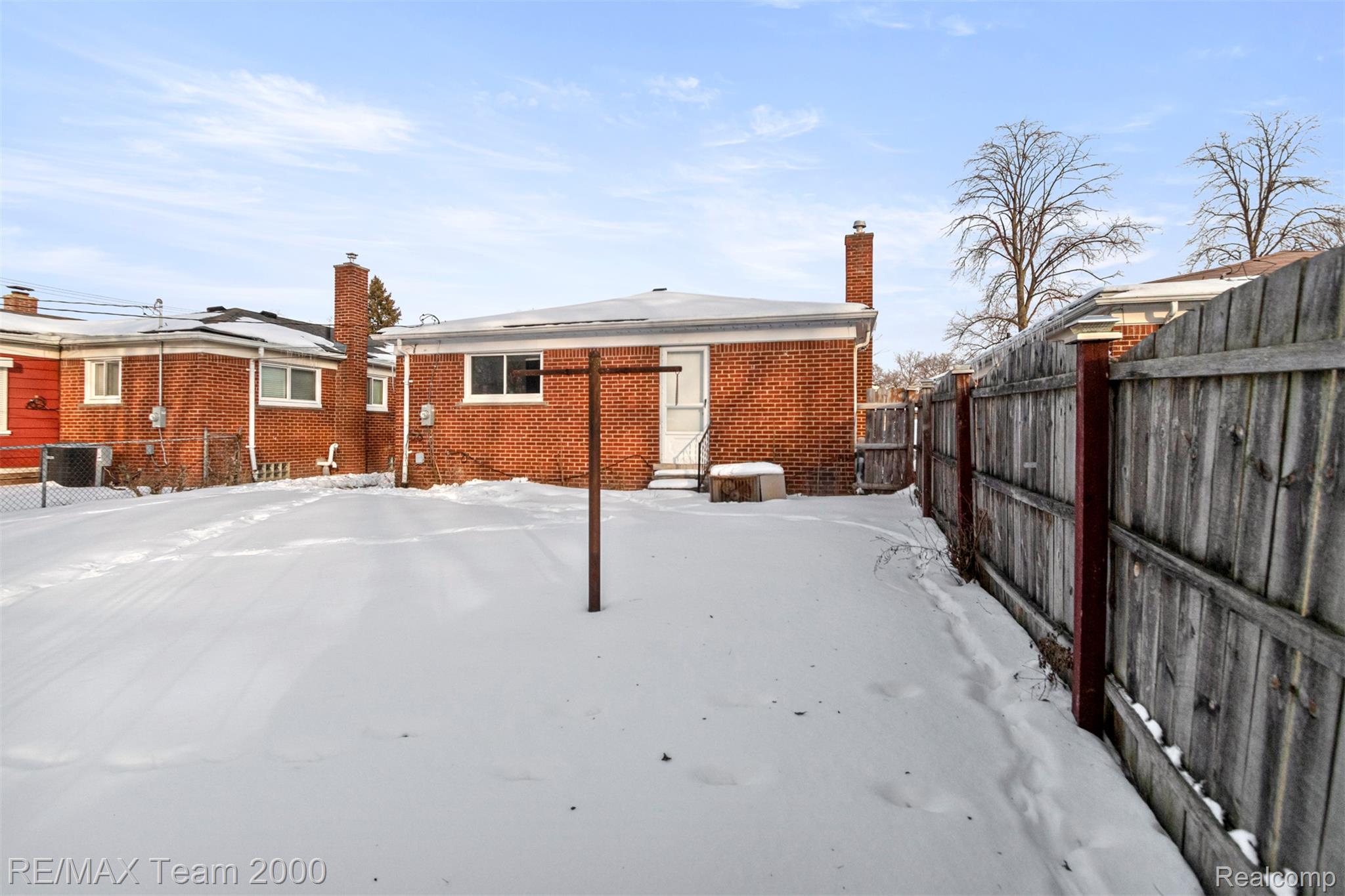 20295 Huntington Road Detroit, MI 48219 - Photo 38 of 43 Snow covered property with a fenced backyard, a chimney, and brick siding