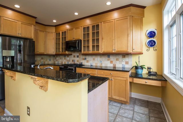 a kitchen with stainless steel appliances granite countertop a sink a stove a refrigerator a microwave and cabinets