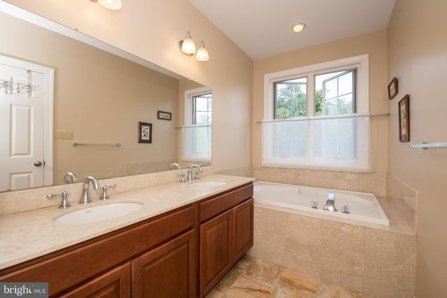 a bathroom with a tub sink and mirror