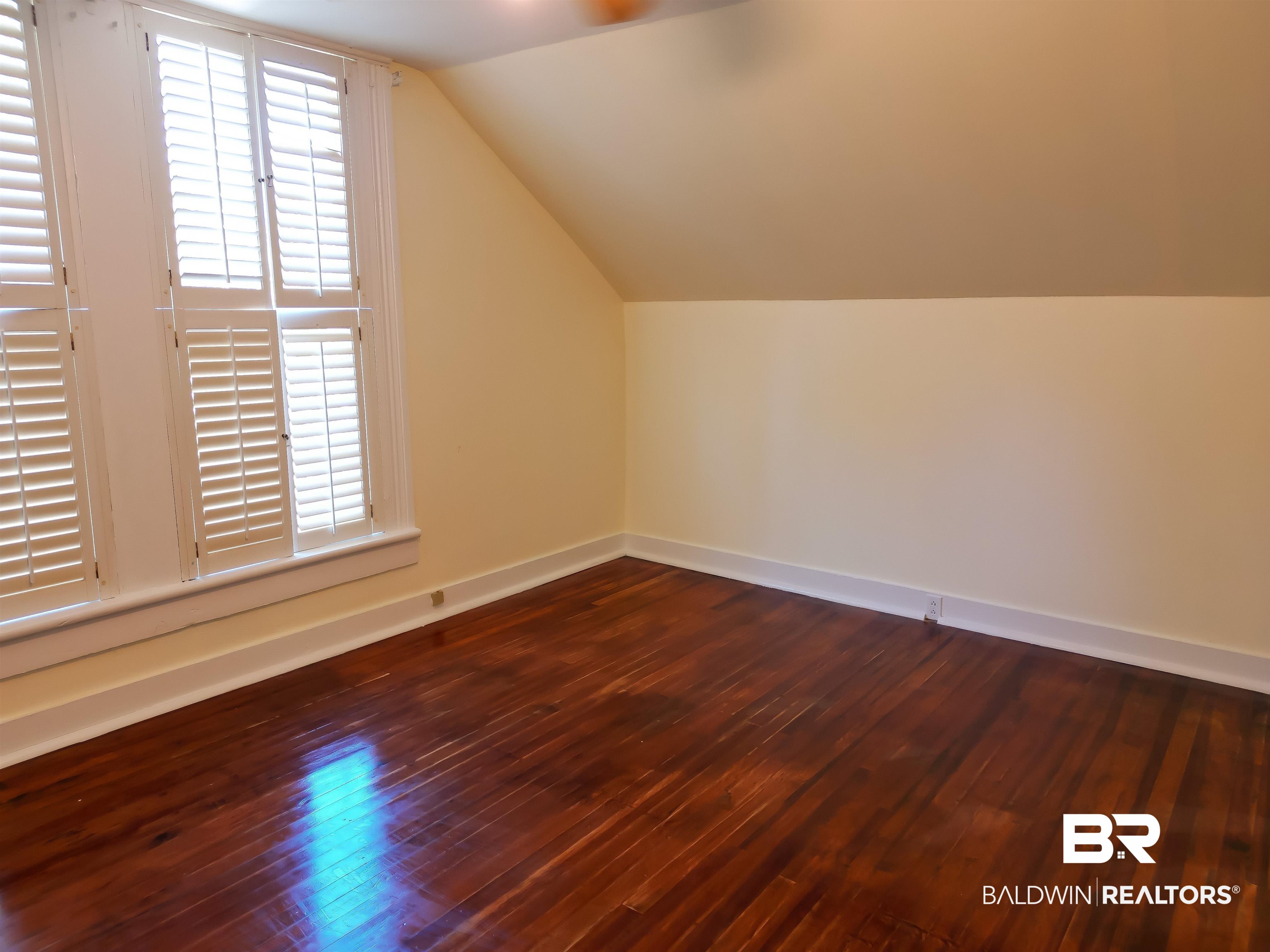 73 Liberty Street Monroeville, AL 36460 - Photo 25 of 29 Additional living space featuring dark wood-type flooring and vaulted ceiling