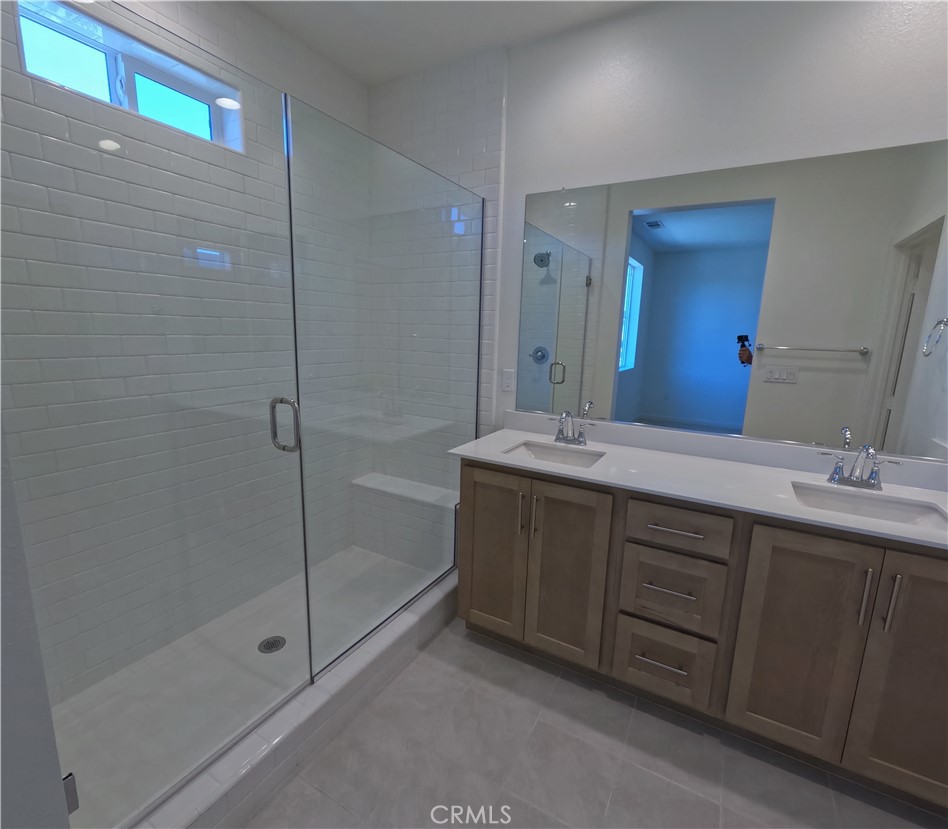 32336 Brunello Way Temecula, CA 92591 - Photo 17 of 25 a bathroom with a double vanity sink mirror and shower