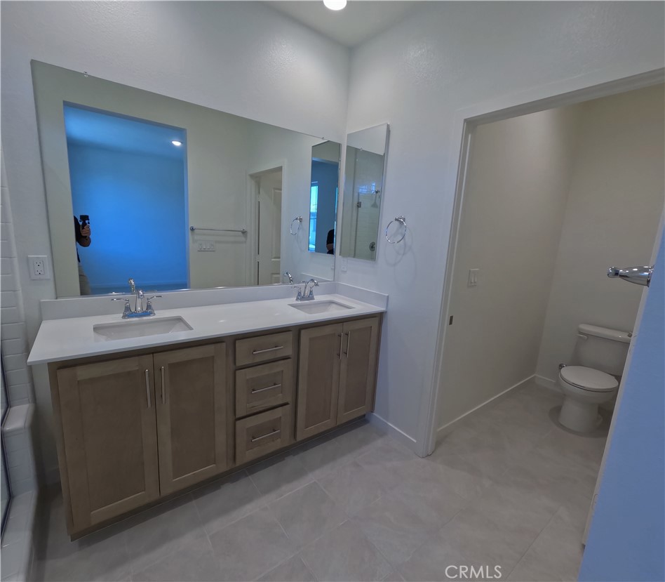 32336 Brunello Way Temecula, CA 92591 - Photo 18 of 25 a bathroom with a double vanity sink toilet and mirror