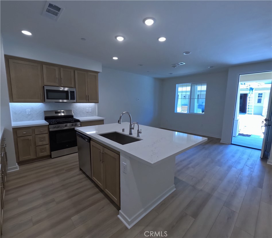32336 Brunello Way Temecula, CA 92591 - Photo 5 of 25 a kitchen with a sink a counter top space stainless steel appliances and a window