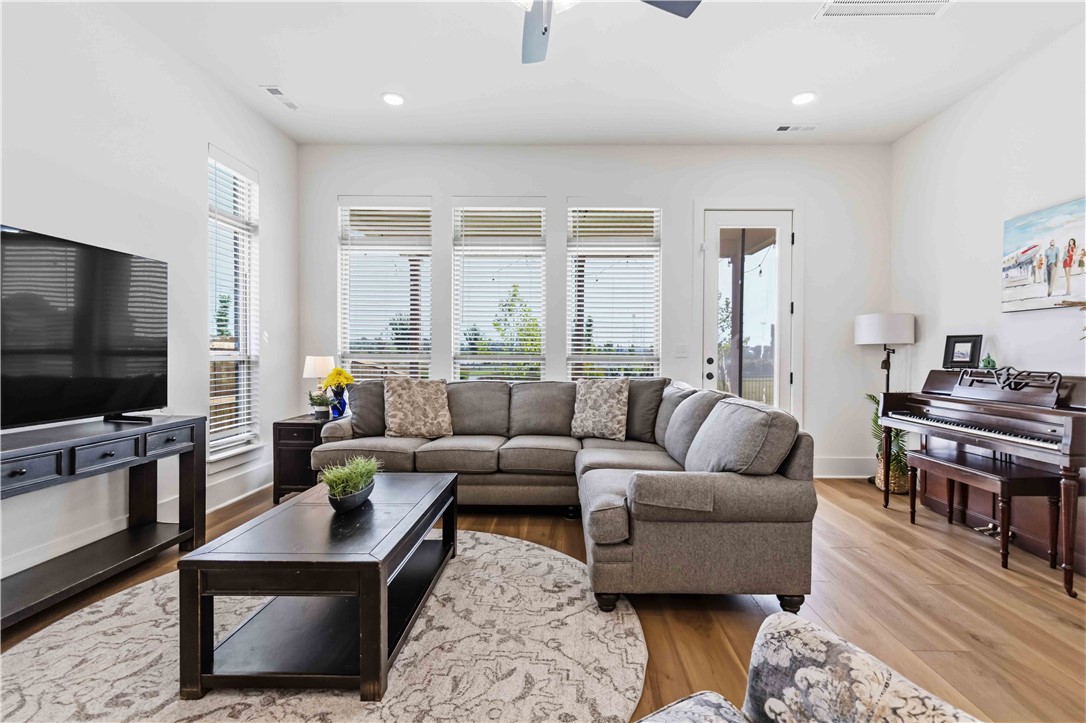 450 Fox Trail Springdale, AR 72762 - Photo 9 of 38 Spacious living area featuring light wood-finish flooring, multiple large windows with blinds, recessed lighting, and a ceiling fan