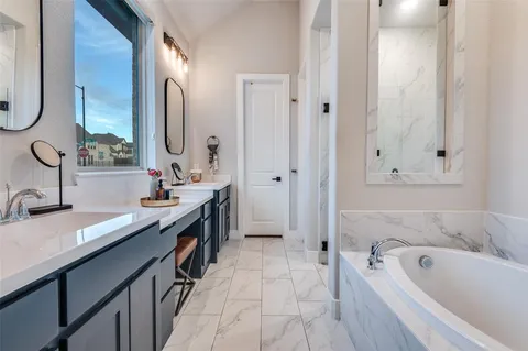 a spacious bathroom with a tub sink and mirror