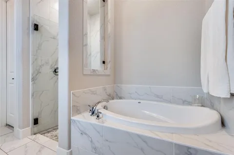 a white bath tub sitting next to a shower