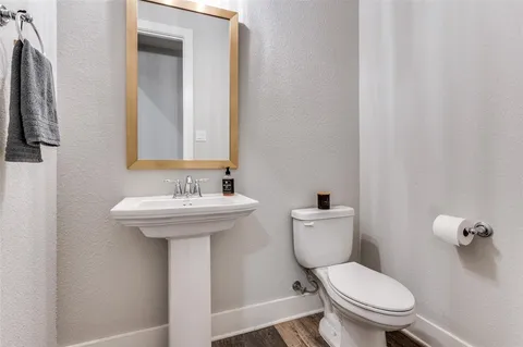a bathroom with a toilet a sink and mirror