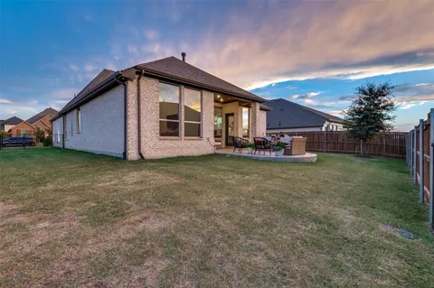 a view of a house with backyard and sitting area