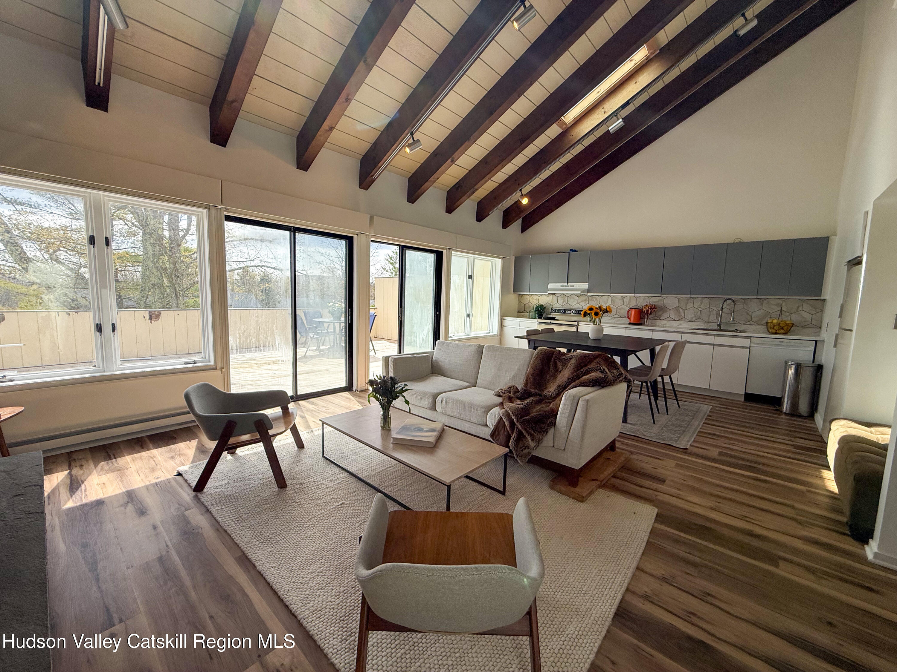 130 Pines Drive, Unit 59 Roxbury, NY 12421 - Photo 12 of 34 a living room with lots of furniture wooden floor and large windows