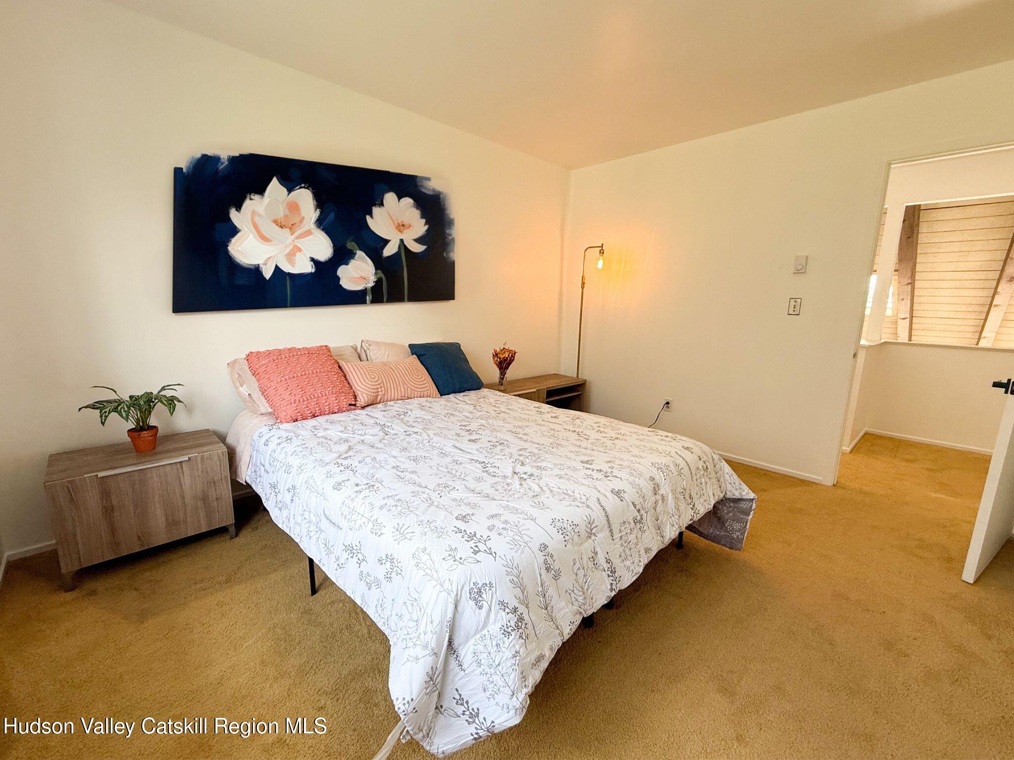 130 Pines Drive, Unit 59 Roxbury, NY 12421 - Photo 27 of 34 a bed sitting in a bedroom next to a window