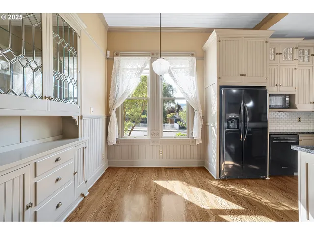 a kitchen with a refrigerator a sink and dishwasher with wooden floor