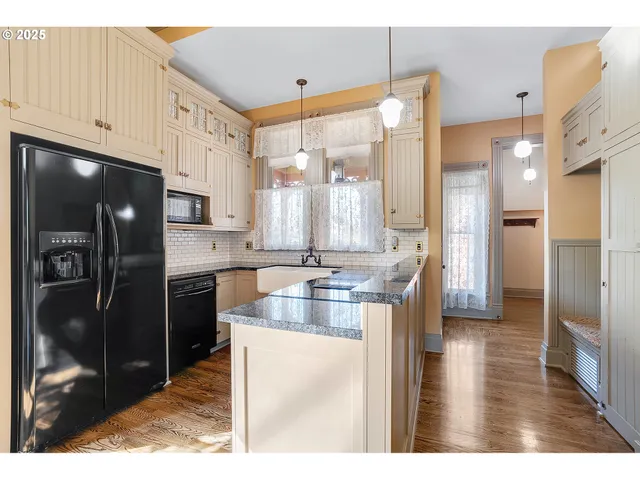 a kitchen with stainless steel appliances kitchen island granite countertop a refrigerator and a stove