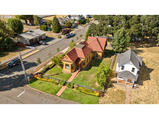 an aerial view of a house with a garden and lake view