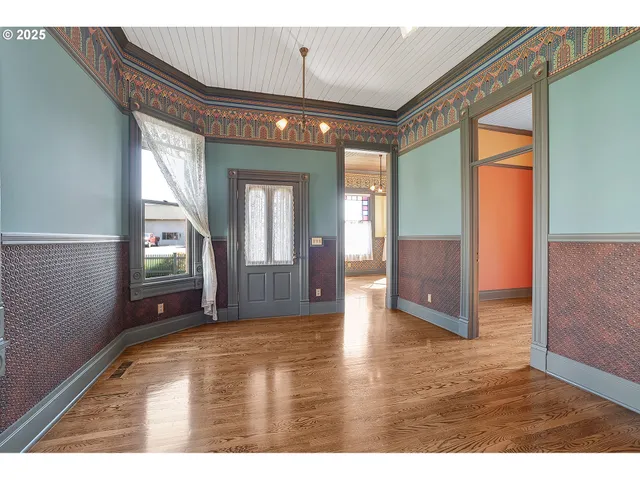 a view of a livingroom with wooden floor and furniture